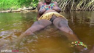 Busty african girlfriend teases naked in a river outdoor