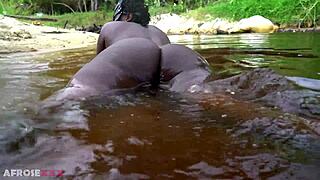 Busty african girlfriend teases naked in a river outdoor