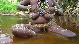 Busty african girlfriend teases naked in a river outdoor