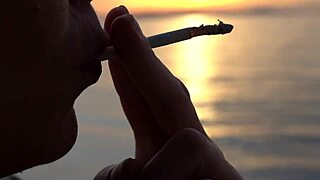 Blonde milf smokes cigarettes on the beach from day to sunset