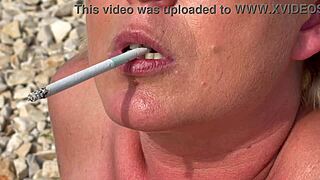 Blonde milf smokes cigarettes on the beach from day to sunset