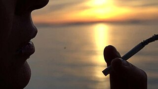 Blonde milf smokes cigarettes on the beach from day to sunset