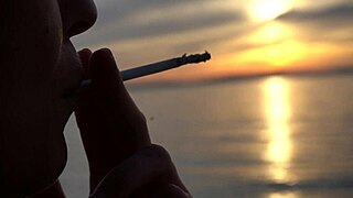 Blonde milf smokes cigarettes on the beach from day to sunset