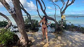 Two pretty brunettes kiss on the public beach at enseada dos corais