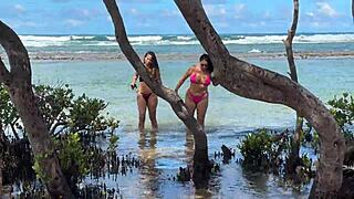Two pretty brunettes kiss on the public beach at enseada dos corais