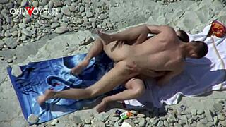 Busty cougar rides hard on beach while voyeur watches, ending with facial cum load