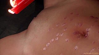 Redhead bound in latex spasms from wax on pussy in outdoor bdsm