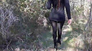 Woman struts sexy in high heels pantyhose strolling deep through forest woods