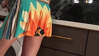 Hot brunette babe in kitchen lifts miniskirt panties off shaved pussy voyeur style