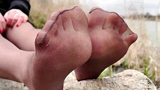 Imagine her nylon-clad feet teasing you in the forest spring—can you resist spreading for her toes?